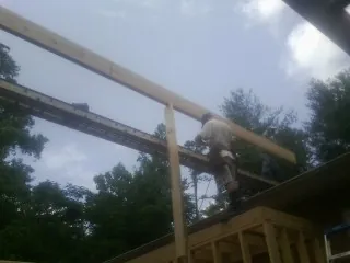 Carpenter setting a ridge beam over a new addition frame — Ice Dam Removal by Roofing Brothers in Beverly Hills