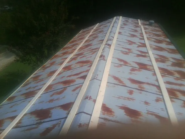 Rusted metal roof panels with new wood purlins before replacement — Storm Damage Roof Repair in Beverly Hills by Roofing Brothers